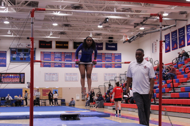 Sophomore Dorothy Yates does a back hip circle on low bar.