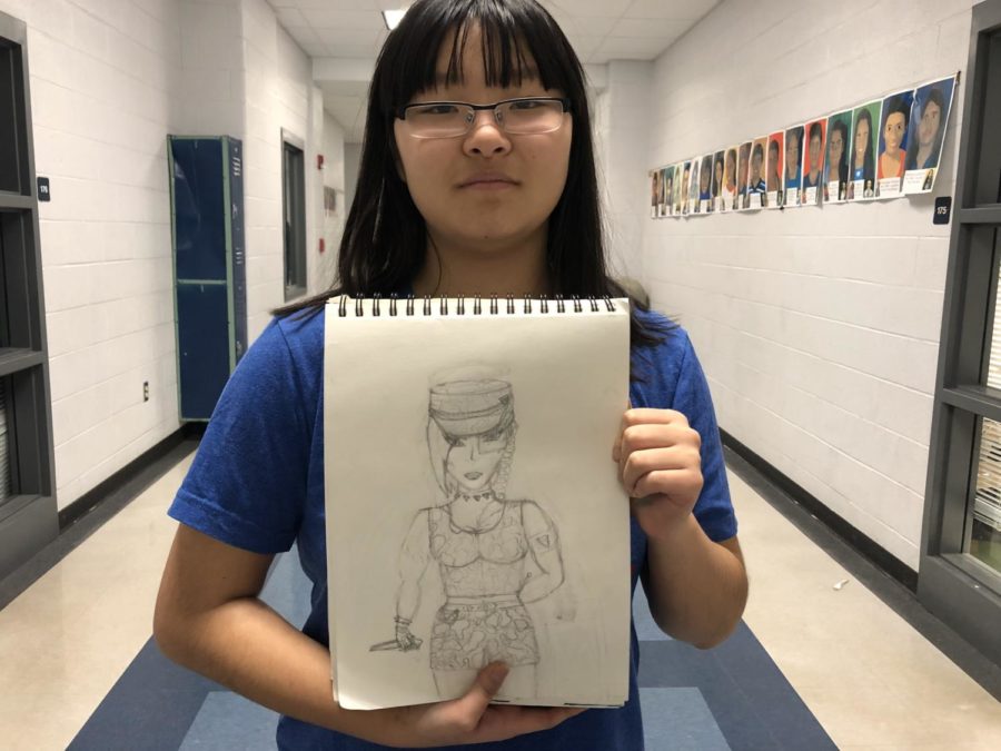 Sophomore June Holm holds up one of her pieces. Holm is running a Manga Art Contest, open to all students.