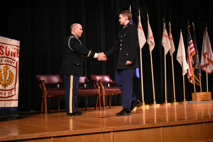 Freshman Cole Phillips shakes hands with Colonel Roy McCutcheon after receiving an award.