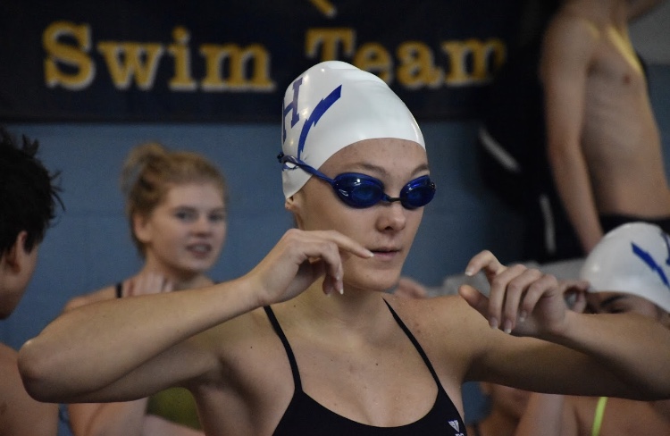 Junior Grace Gabriele prepares for her event at one of the swim meets on the Streaks swim team. Gabriele spends the majority of her time swimming, but also make sure she leaves room for personal training time at the gym. 