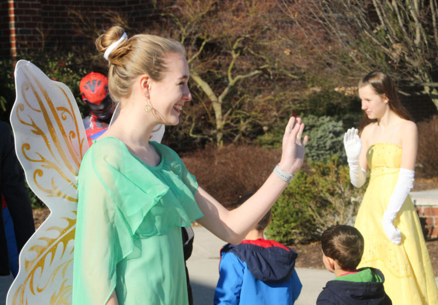 Junior Claudia Obenschain as Tinker Bell happily waves to the elementary students as they arrive.