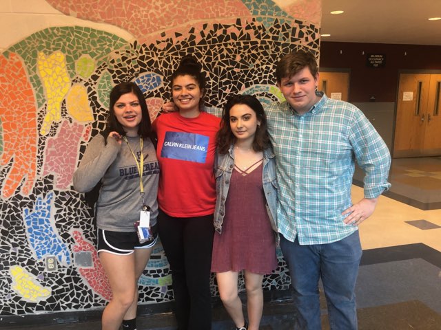 Seniors Anna Rath, Farah Raghab, Elisavet Savides and James Frakes gather in the auditorium commons for a group picture.