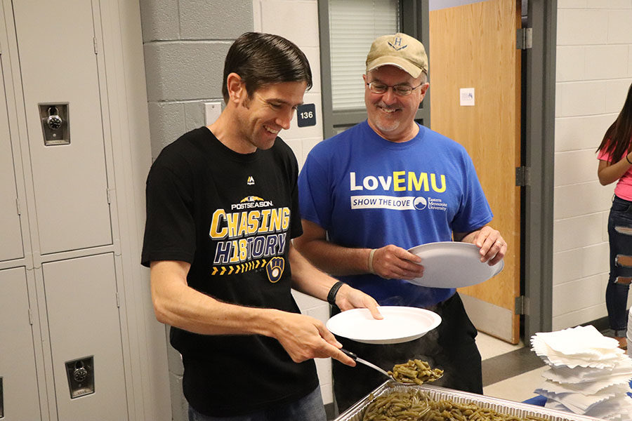 Teachers Gehrie Bair and Jerry Hertzeler serve themselves food.
