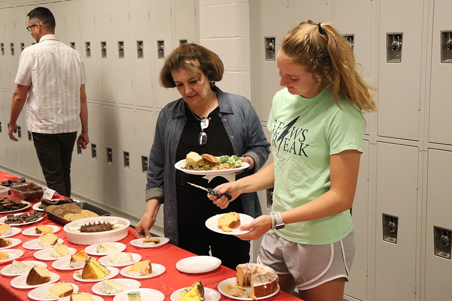 Sophomore Sophie Sallah helps another teacher with their second plate.