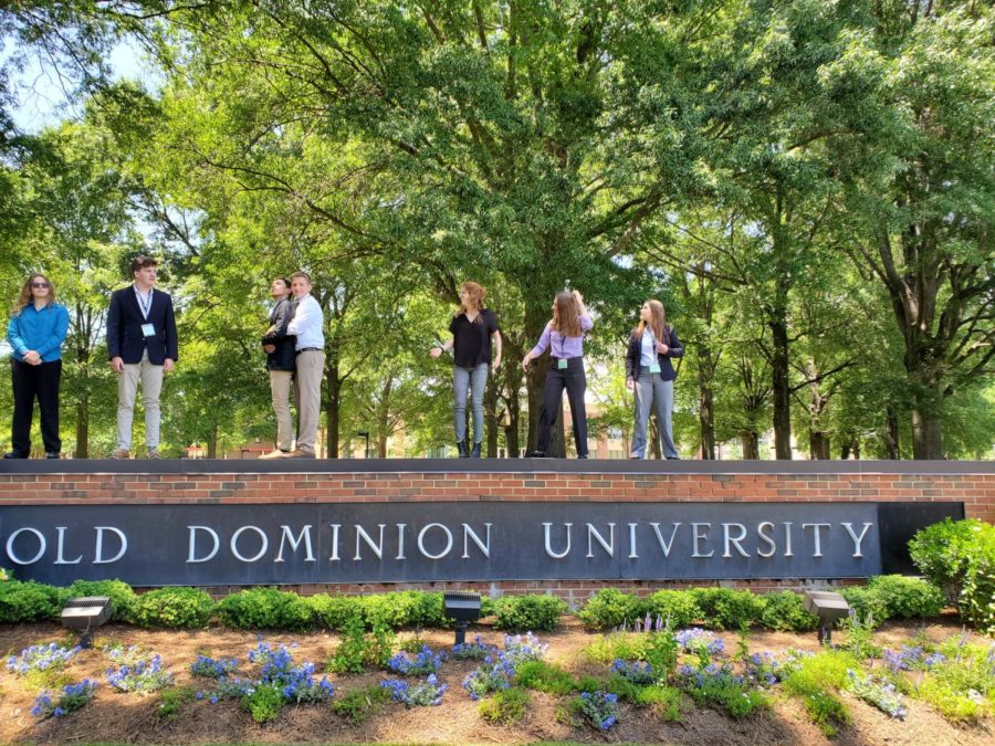 (Left to right) Jade McLeod, Noah McIntire, Fernando Posada, Tucker McGrath, Hannah Miller, Andi Fox and Christa Cole stand atop the sign at Old Dominion University before a presentation. 