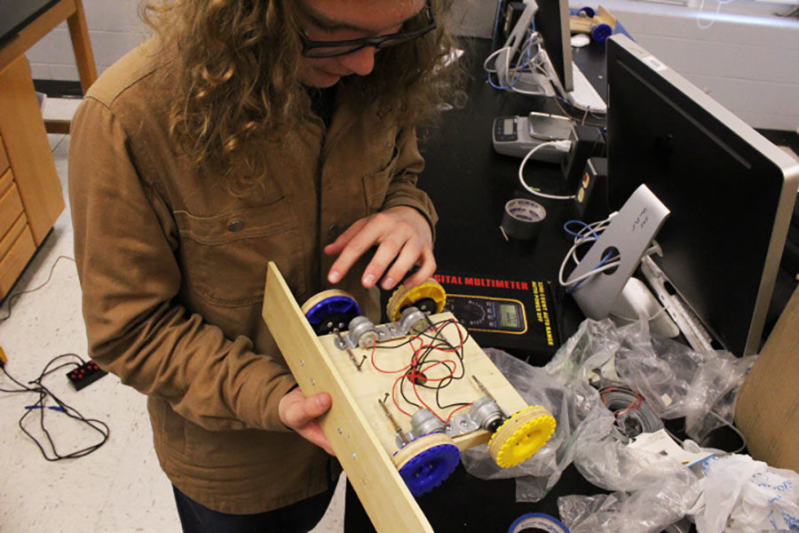 Junior George Shirkey examines the wires that attach to the remote.