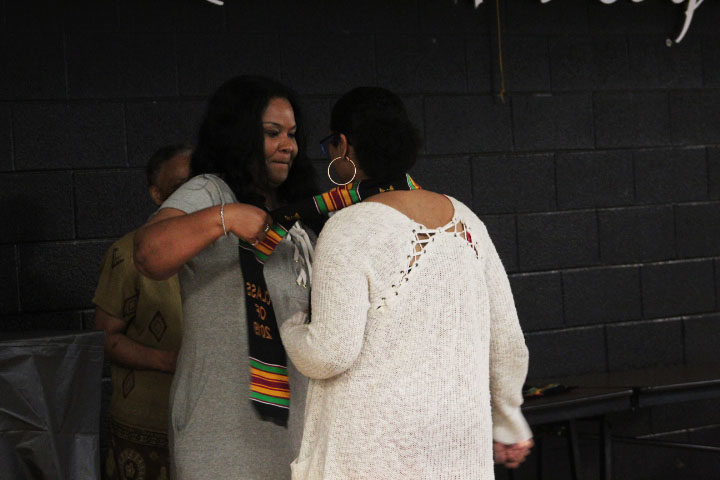 Senior Salem Addisu dons the Kente stole given by advisor Cassandra Copeland