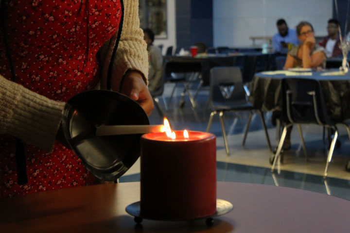 A candle is held to a flame during the lighting ceremony of the Black Student Union banquet.