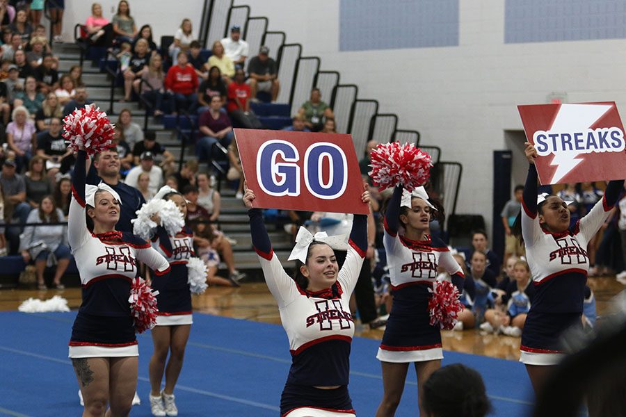 Junior Chloe Nichols holds up a sign to help involve the crowd in a cheer.
