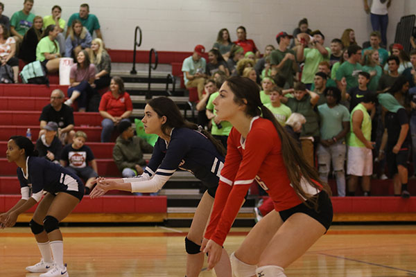 Junior Dany Medhin,  and seniors Sydney Plowman and Abby McCollum get down for a serve.