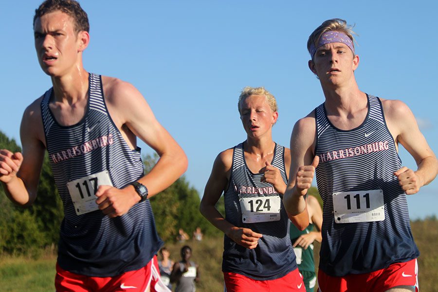 Seniors Alex Neufeld and Michael Hulleman run alongside sophomore Micah Tongen in the City County Championships at Peak View Elementary. The boys team won first place in the district. 