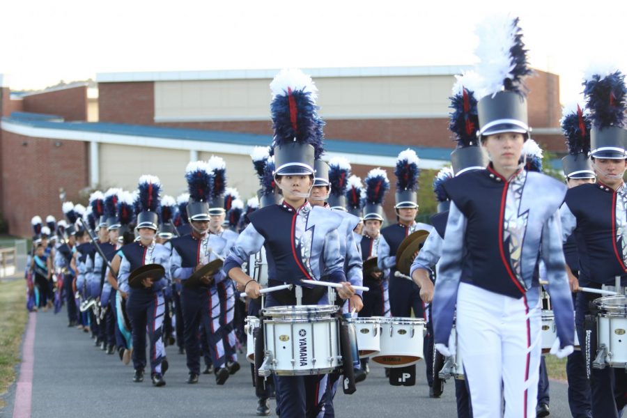 The HHS marching band marches towards the football field after the tailgate at the home football game Sept. 20, 2019. 