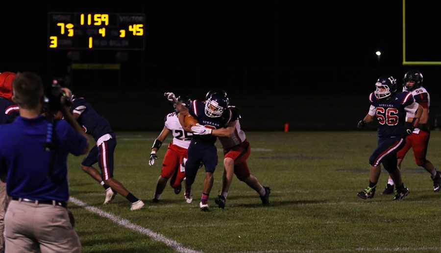 Attempting to get yard needed for a first down, senior Kwentin Smiley (#9) pushes through the Sherando defense.