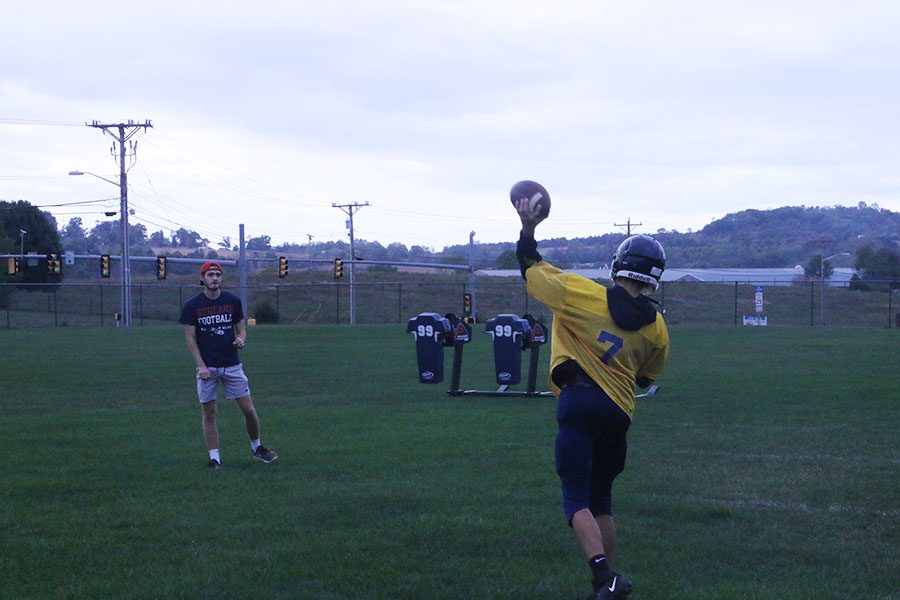 Burgess works on perfecting his throw with Assistant Coach Sam Healy.
