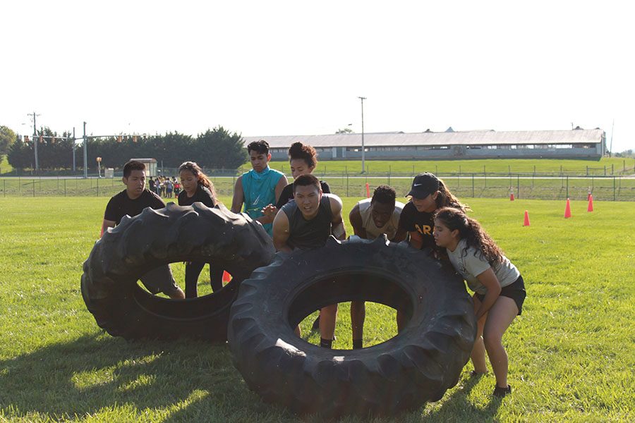 In the team physical fitness course team C flips tires for the JROTC Raider Camp.