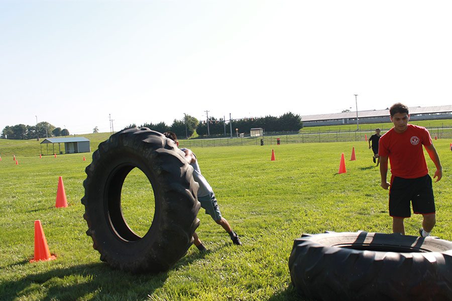 Cadet Major junior Jeremias Domingo and Cadet Captain sophomore Guillermo Lopez flip tires alone, while they let their team catch up. 