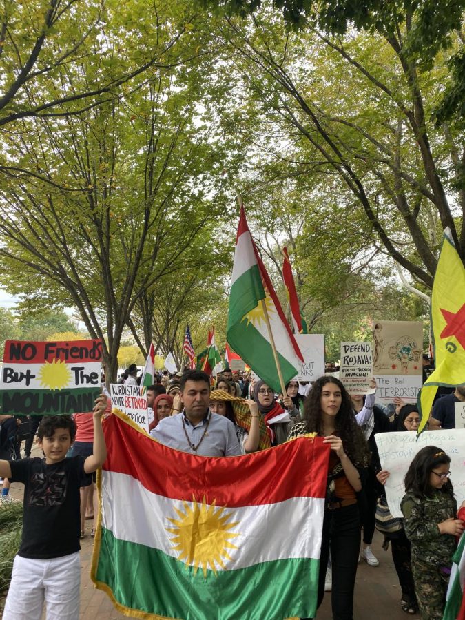 Junior Sollen Haji holds onto a Kurdish flag while walking with other protestors.