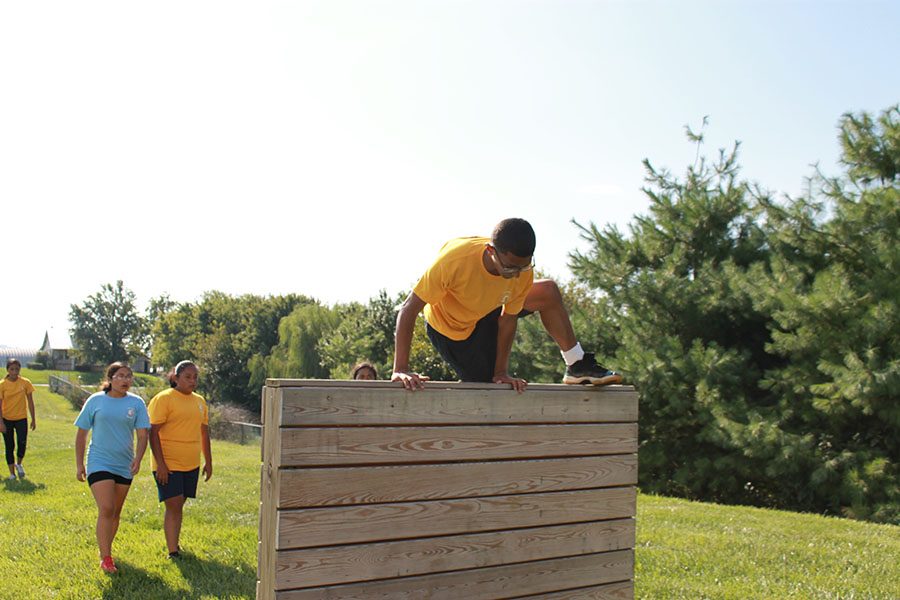 Cadet Corporal Freshmen Jp jumps off the wall for the team physical fitness course.