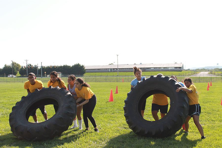 D team starts to flip tires in the team physical fitness course. 