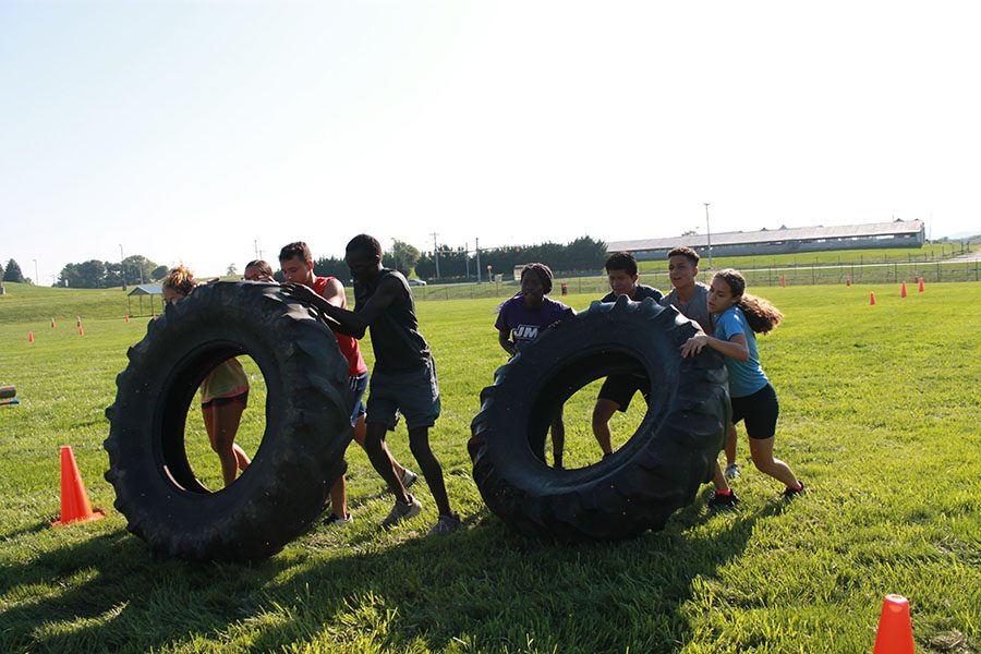 A team flips tires for the team physical fitness course. 