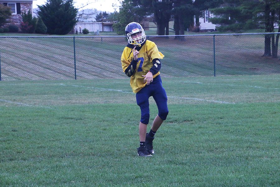 Freshman Quarterback Jadon Burgess tosses the football to warm up before practice.