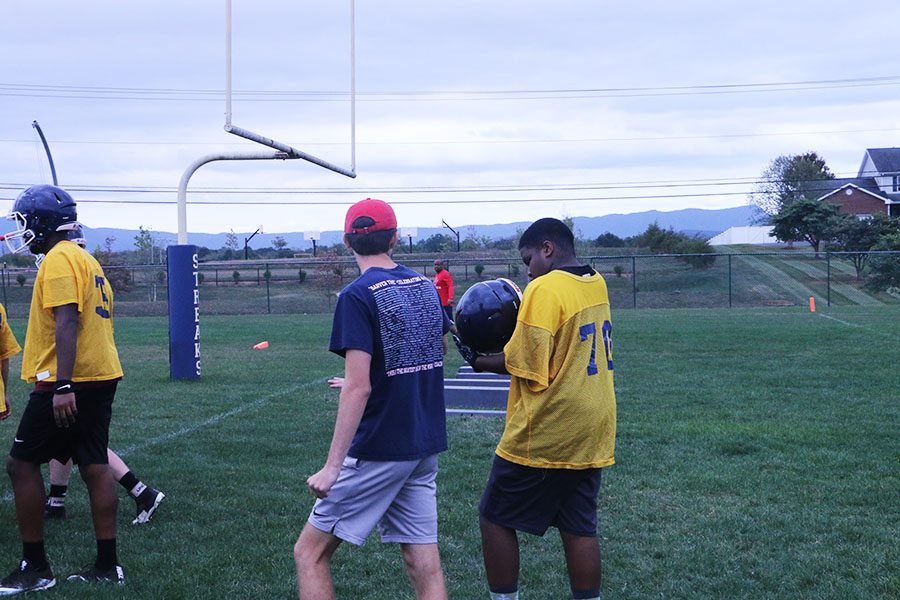 As practice concludes, Coach Healy takes a moment to help freshman Sam Mosley.