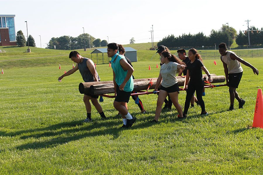 C team carries logs for the team physical fitness course. 