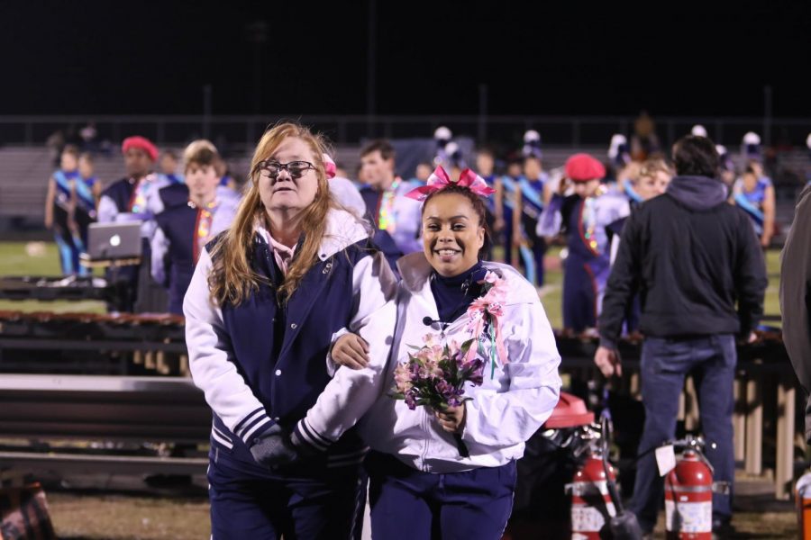 Junior Maria Jurado walks out with Melissa Thurman, her cheer coach, at halftime.