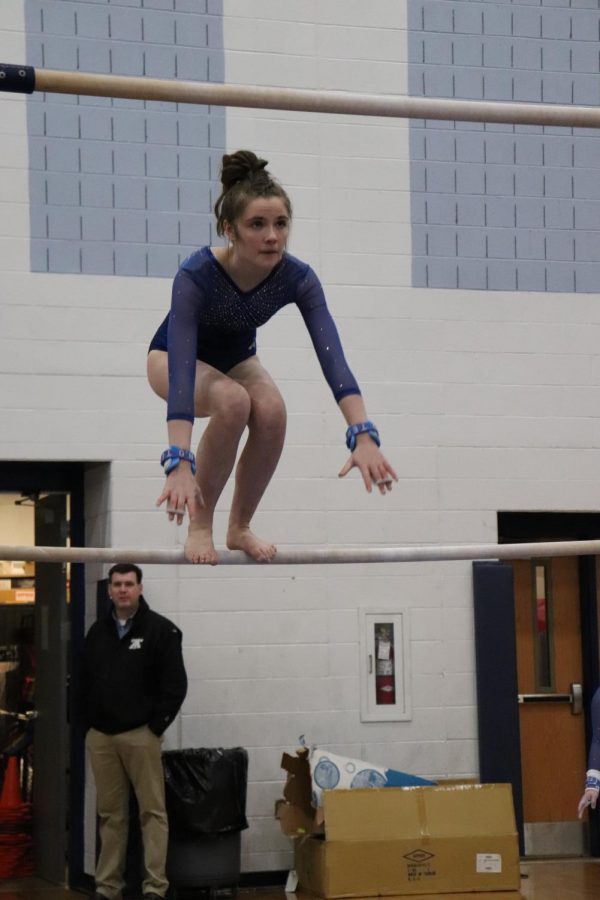 Junior Elizabeth Healy jumps to the high bar during her routine.