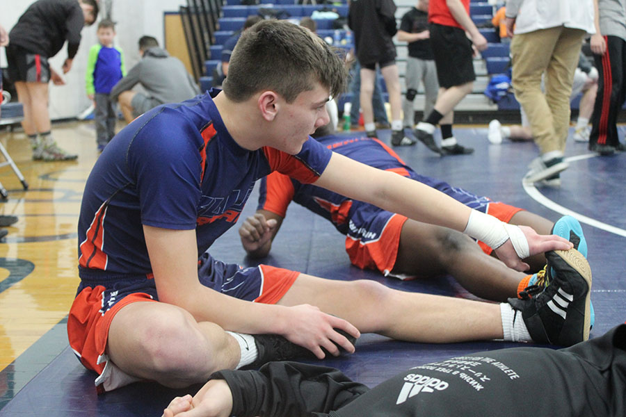 Freshman Nathan White  stretches in between matches. 
