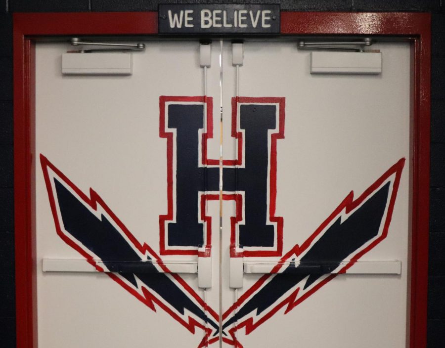 Varsity football coaches Joe Carico, Marc Healy and Josh Carico painted the inside of the weight room doors white with the Harrisonburg High School logo and painted the trim red.  