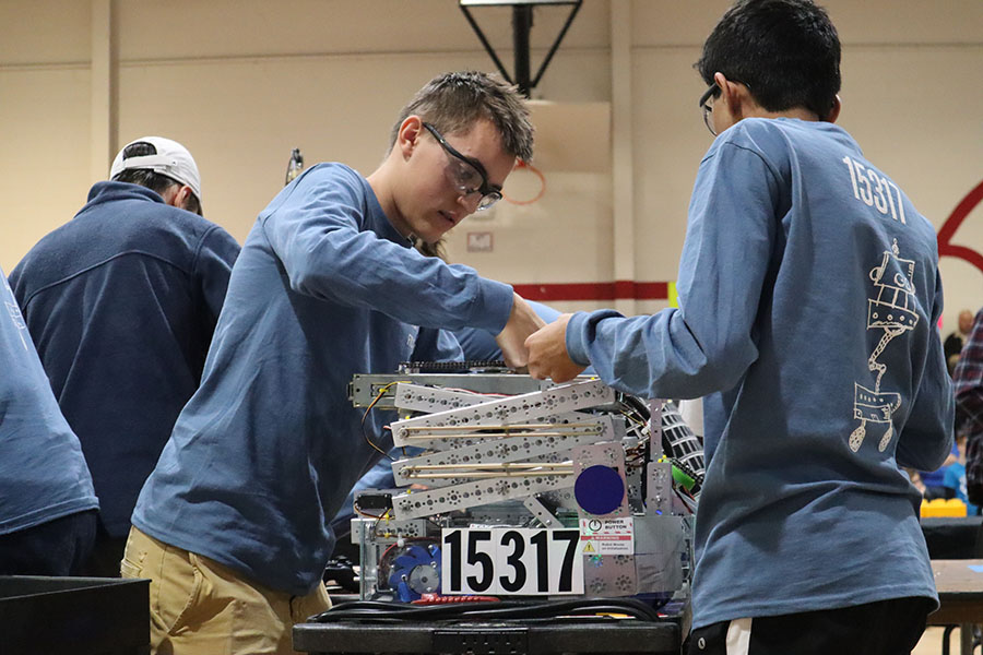 Junior Thomas Shulgan and freshman Niranjan Aradhey edit their robot while waiting for a match.