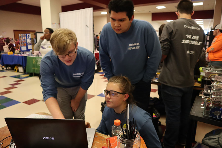 Juniors Carlo Mehegan, Eva Velker and HHS computer science teacher Jon Stapleton attempt fix the programming for team Error 404's robot.