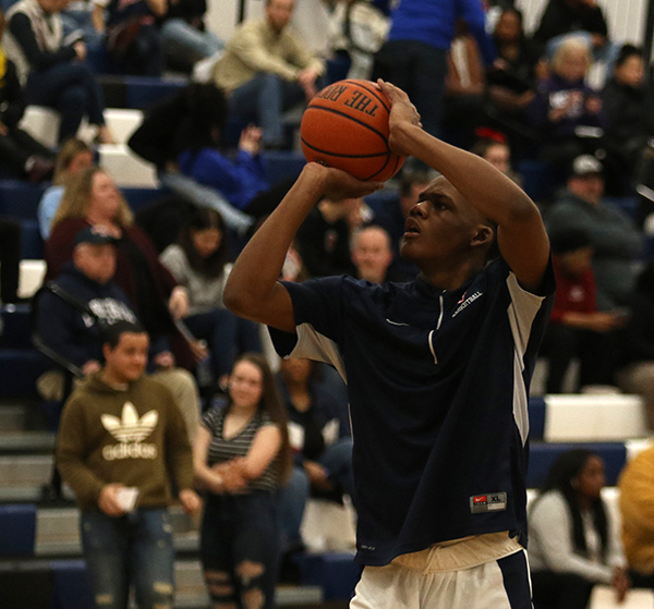 Senior Michael Kuangu practices his free throws during warm-ups before the game.