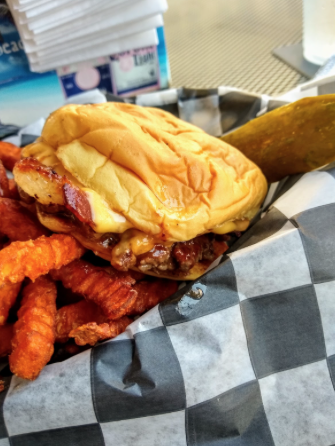 A burger from Jack Brown's is presented with a side of sweet potato fries. 