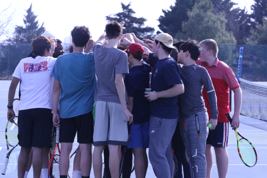 The HHS boys tennis team huddle together before their tennis matches. 