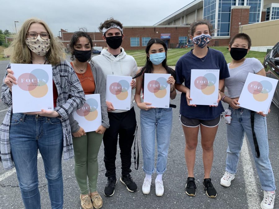 The 2019-2020 yearbook editorial board standing with the yearbook. 