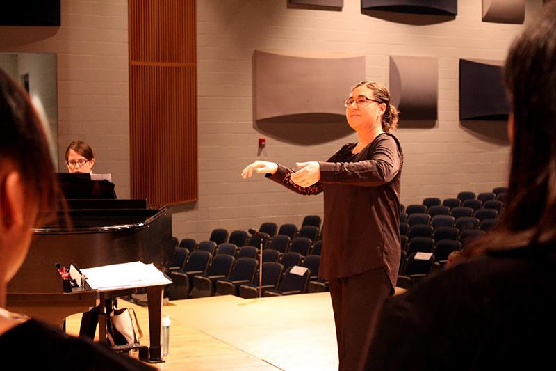 Choir teacher Bethany Houff conducts her students during a concert. 
