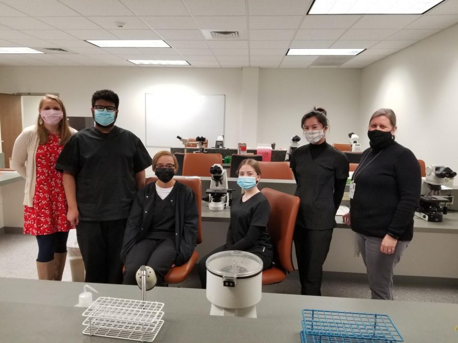 (From left to right) Phlebotomy school instructor Emileigh Conley, senior Michael Pacheco-Carrillo, senior Makayla Runion, senior Viktoria Katykhin, senior Emily Nguyen, and program director Cyndee Lowe stand together prior to class. 