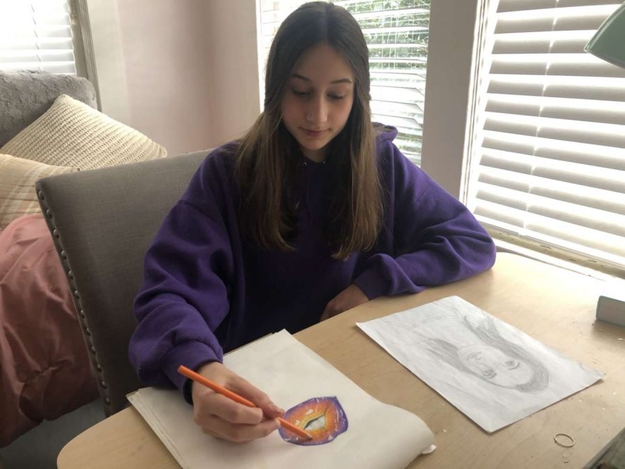 Freshman Anna Campillo works on a drawing of lips in her room. 