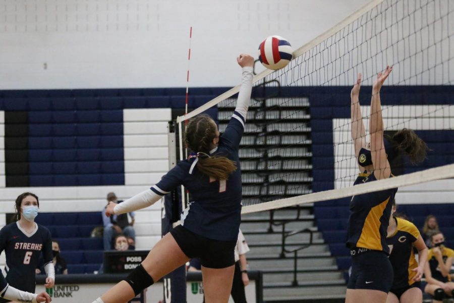 Freshman Lucy Ludwig reaches up to bump the ball over the net.