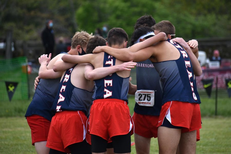 The boys cross country team huddles before their race. The boys team placed second at the regional meet, qualifying them as a team for the state championship.