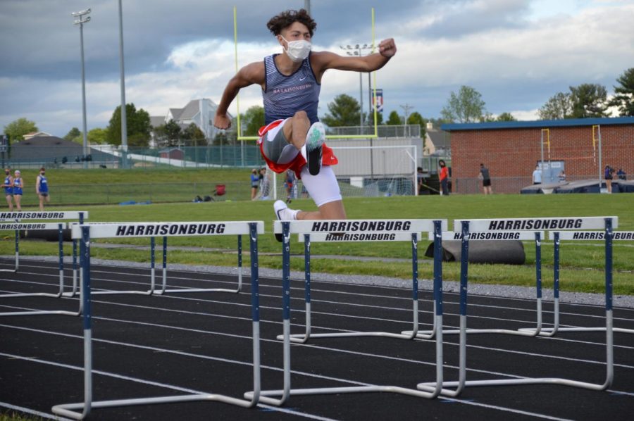 Sophomore Jadon Burgess jumps over a hurdle. 
