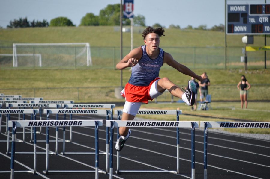 Sophomore Jadon Burgess jumps over a hurdle.   
