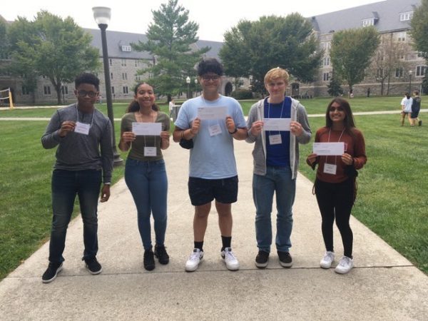 (Left to right) Seniors Jory James, Haile Madden, Jafar Mansoor, Adam Osinkosky and Aroob Ahmed hold up their envelopes prior to finding out their admissions decision after the conclusion of fall visitation weekend at Virginia Tech.