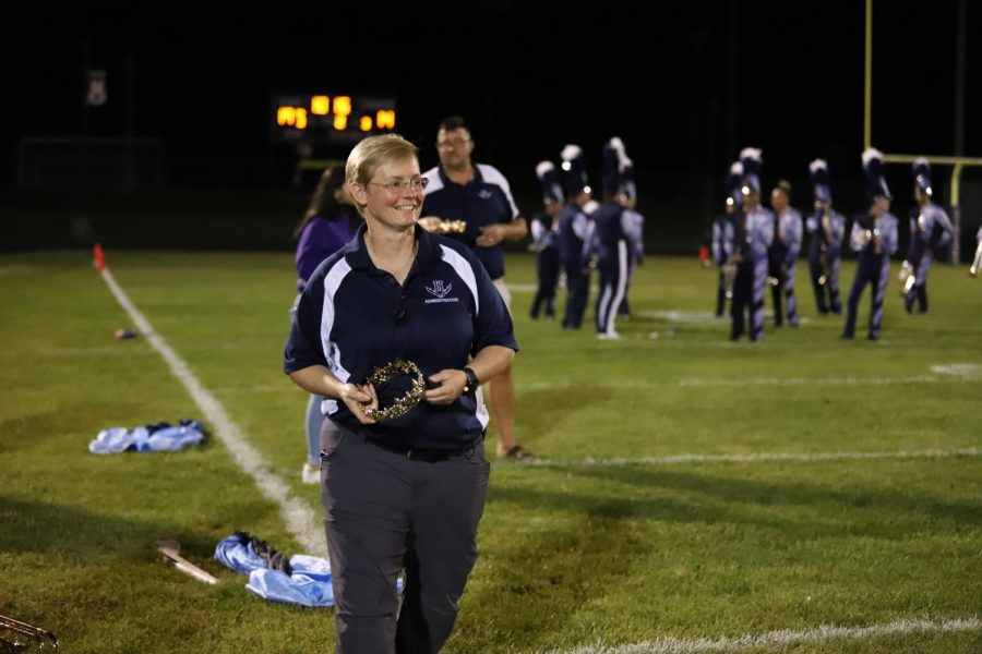 Principal Melissa Hensley  presents homecoming crowns to elected royalty during halftime of the varsity football game. 