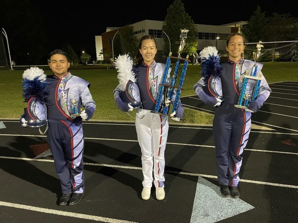 Seniors and assistant drum majors Mikey Paniagua, Jeslyn Liu and AJ Moats hold their trophies from the Star City Classic competition. 