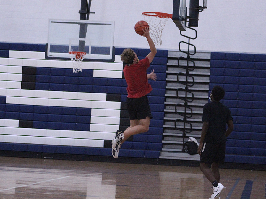 Senior Evan Bert goes up to dunk during tryouts.