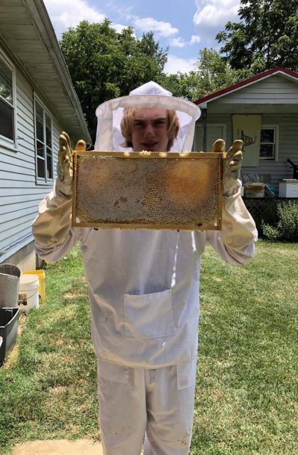 Junior Wyatt Tinkham poses with his new bee hive after completing a hive check.