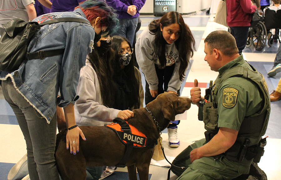 Reese the dog helps a group of students learn about conservation police careers.